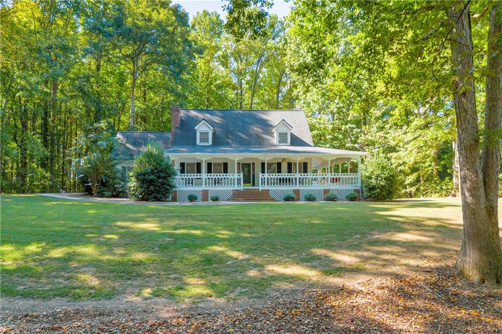 a view of a big house with a big yard and large trees