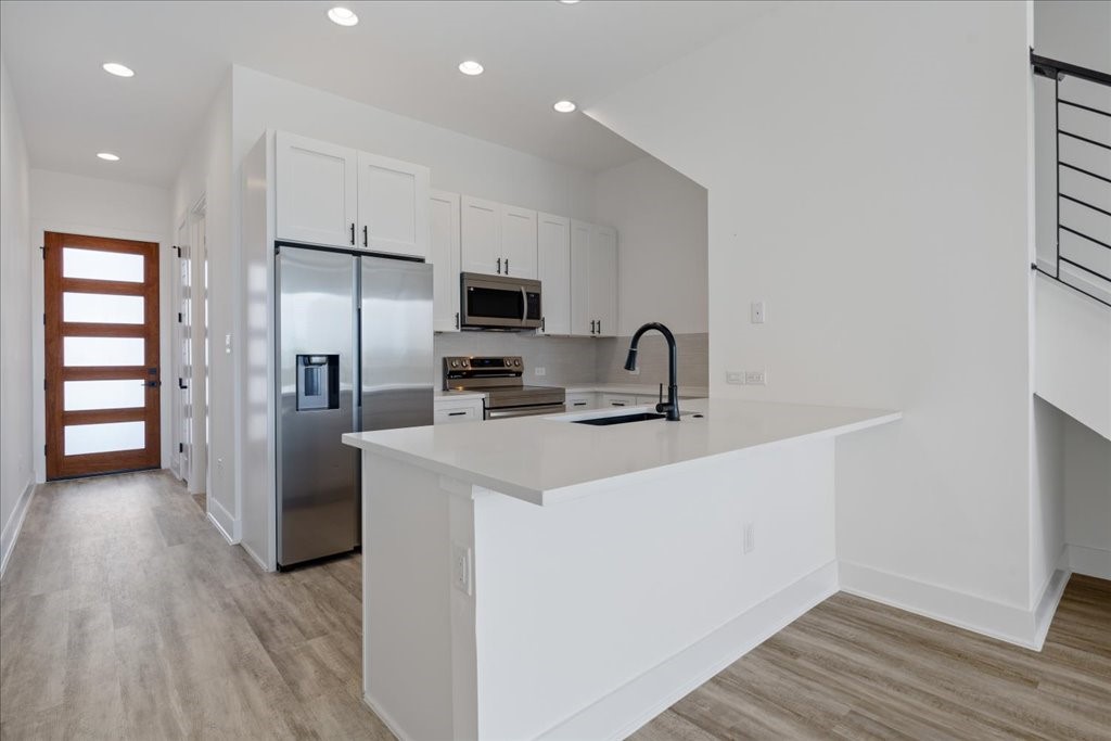 a kitchen with a refrigerator sink and cabinets