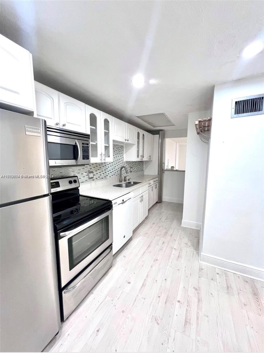 a kitchen with stainless steel appliances a stove microwave and a refrigerator