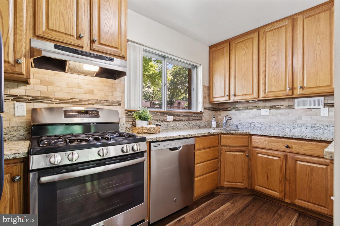a kitchen with stainless steel appliances granite countertop a stove a sink and cabinets