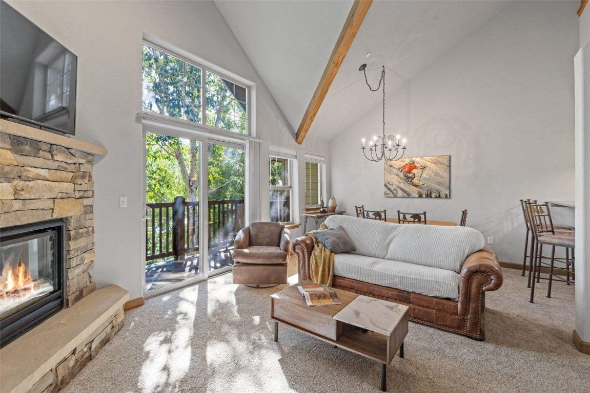 a living room with furniture a fireplace and a floor to ceiling window