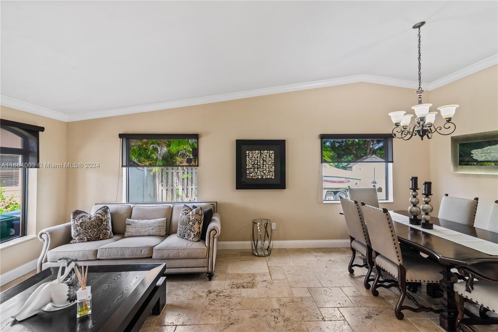 a living room with furniture a chandelier and a window