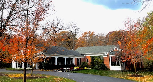 a front view of a building with trees and retail shops