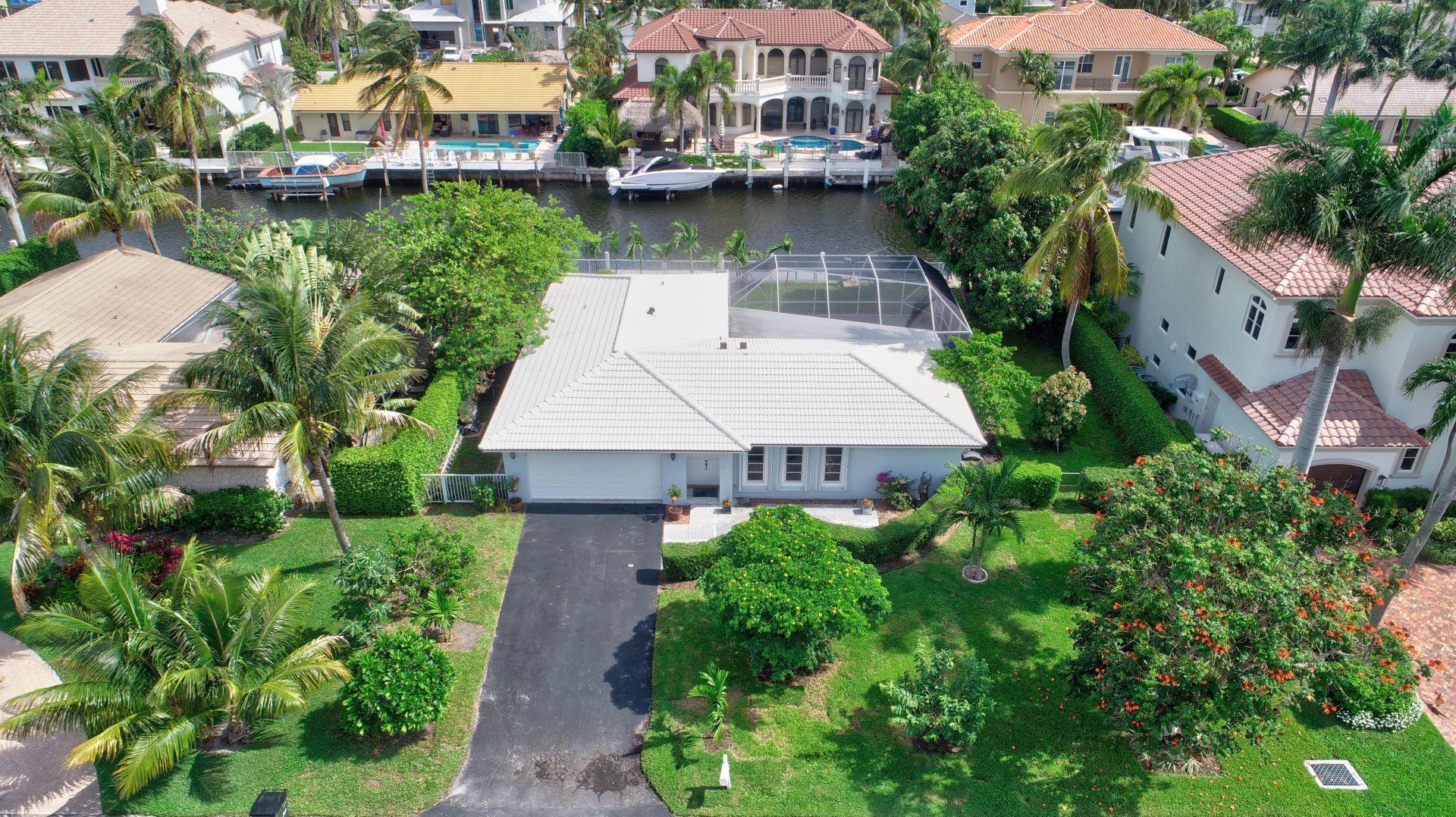 an aerial view of a house with garden space and a lake view in back