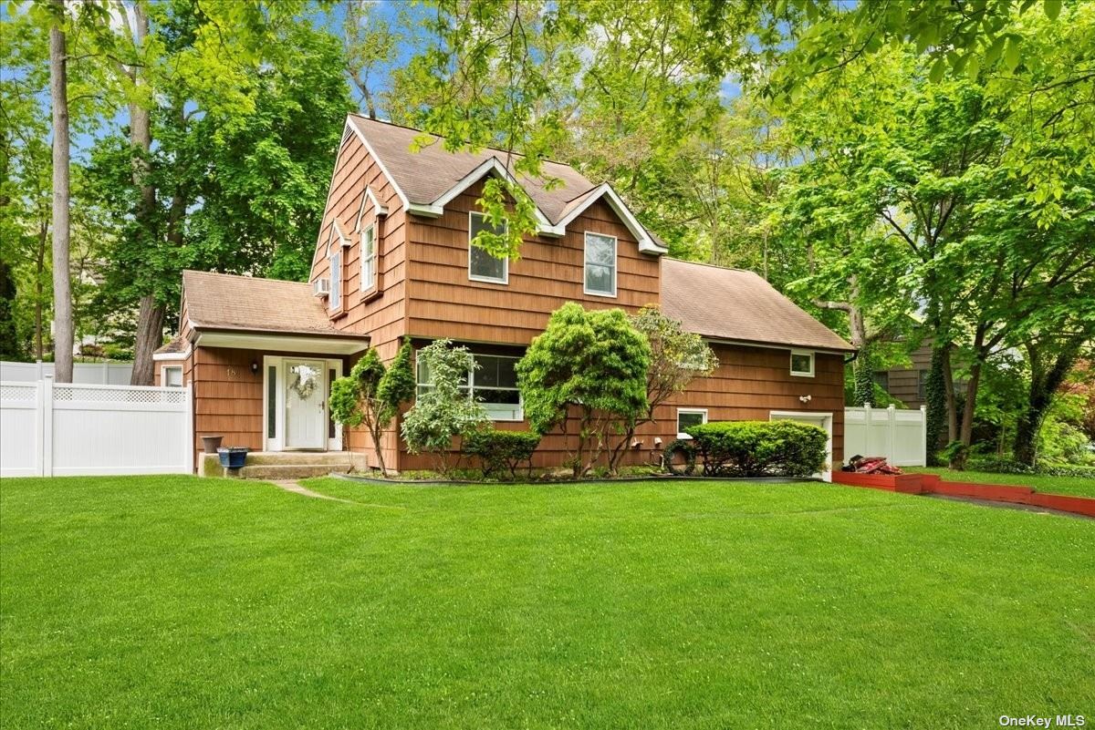 a front view of a house with a garden and trees