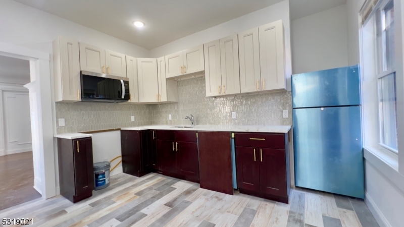 a kitchen with a refrigerator and a stove top oven