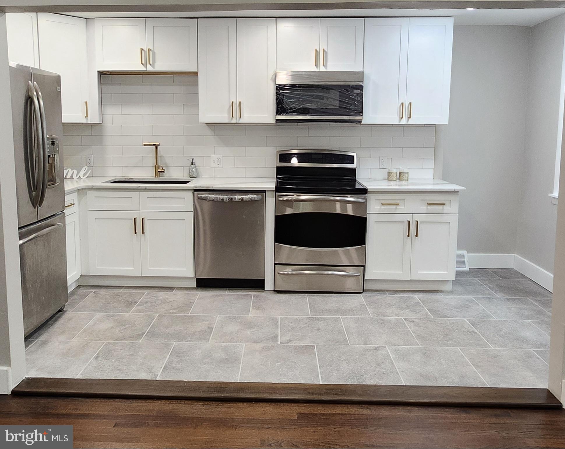 a kitchen with granite countertop white cabinets and white appliances