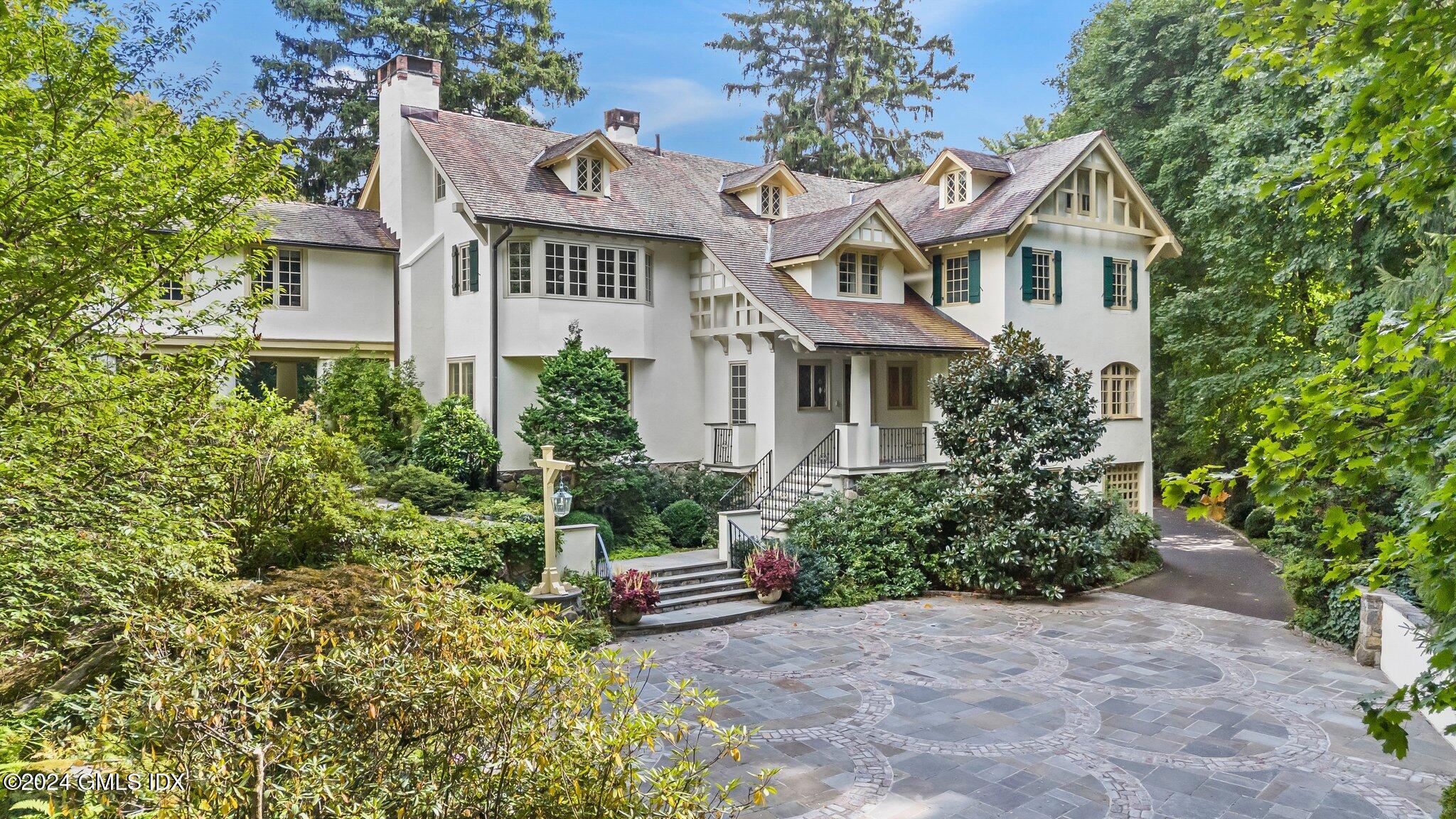 a view of a white house with a yard and plants