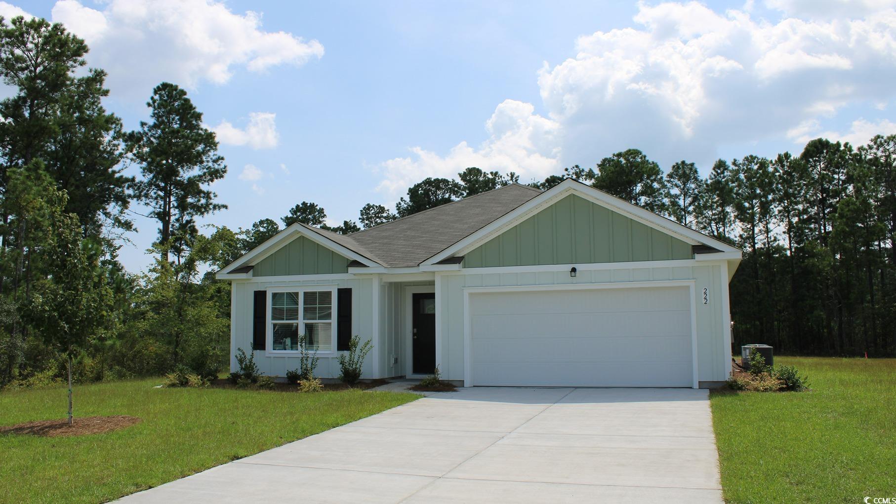 View of front facade with a garage and a front law