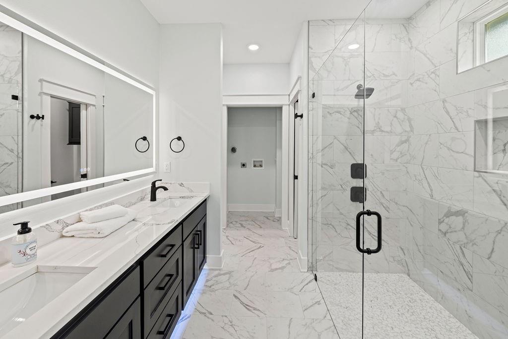 a bathroom with a granite countertop sink a shower and a mirror