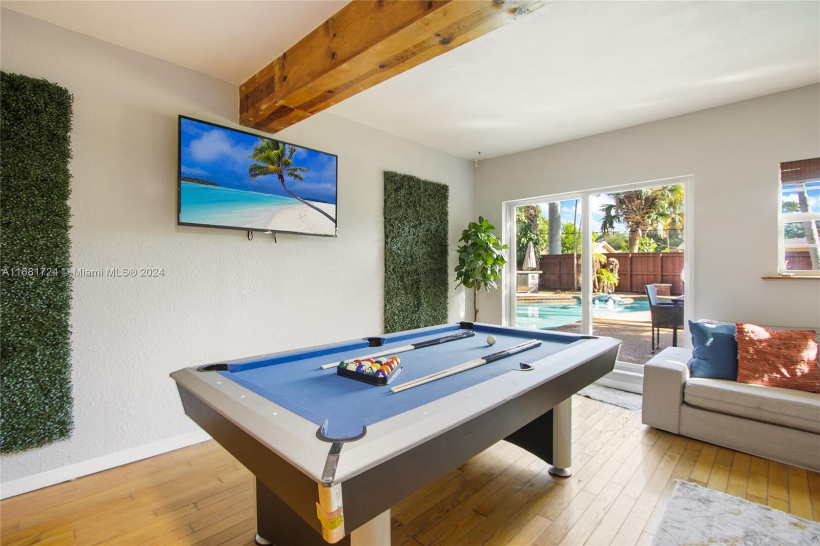 a living room with furniture pool table and windows