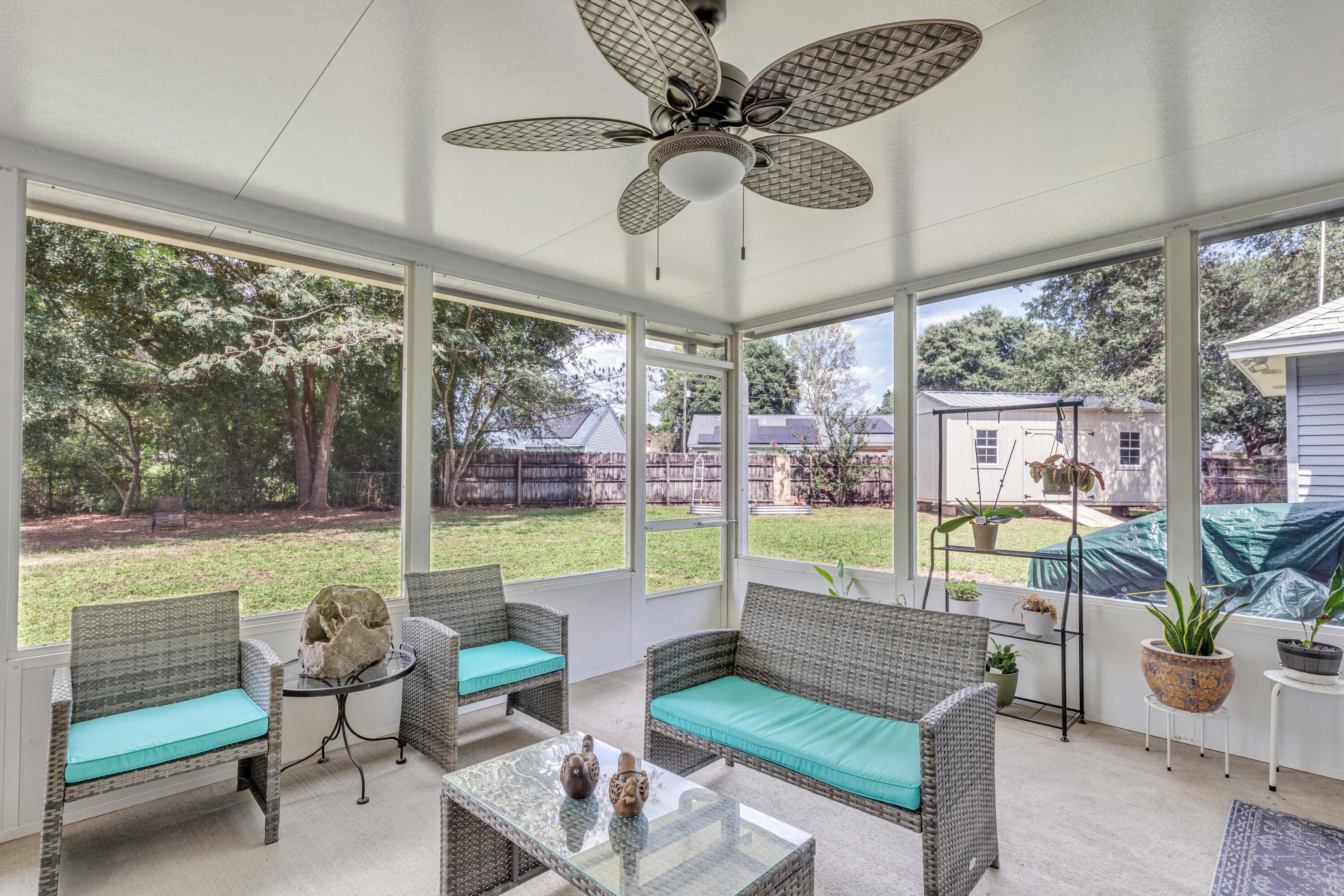 a living room with patio furniture and a floor to ceiling window