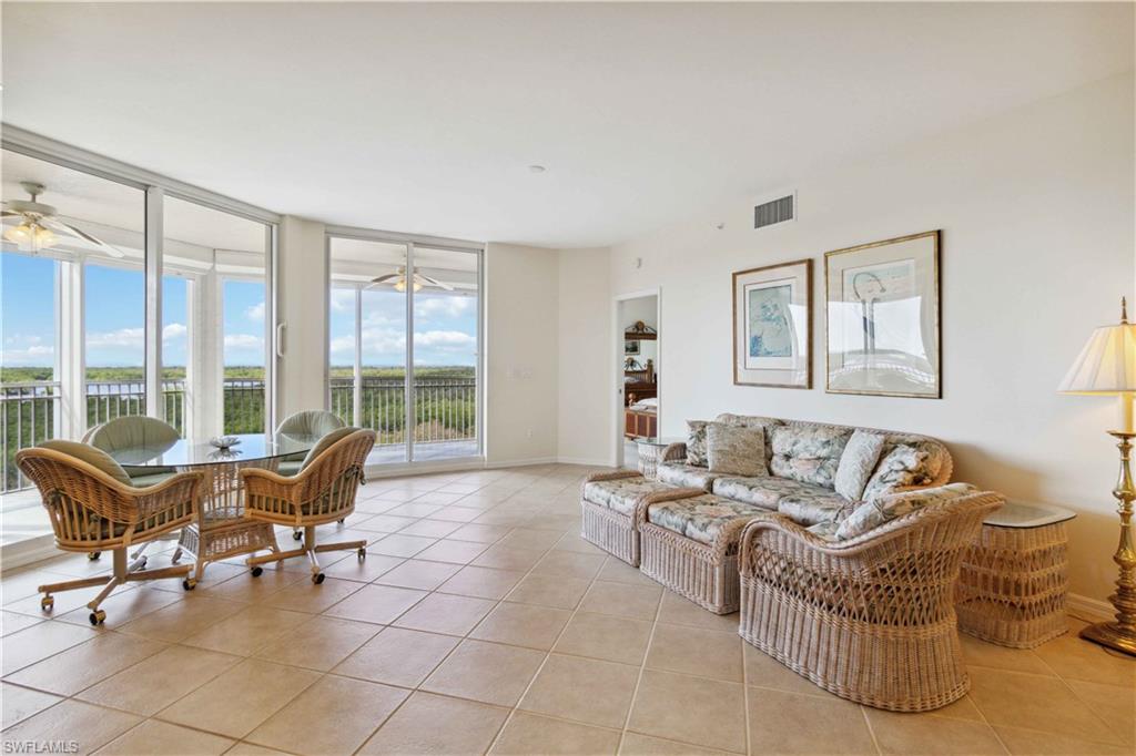 a living room with furniture and floor to ceiling windows