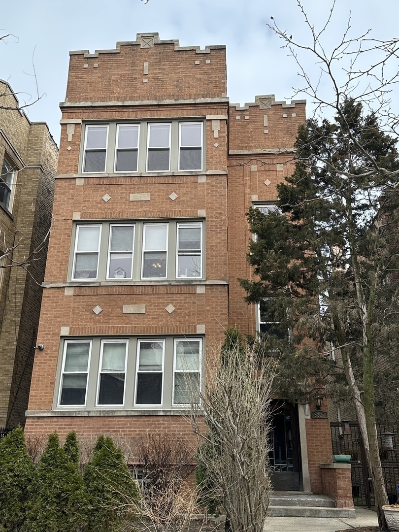 a front view of a building with a garden