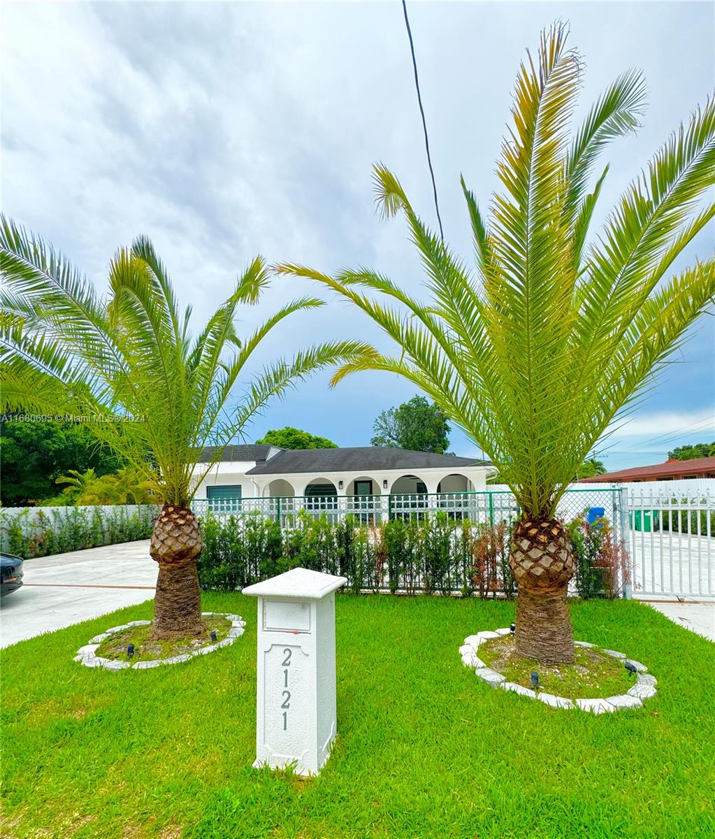 a front view of house with swimming pool and green space