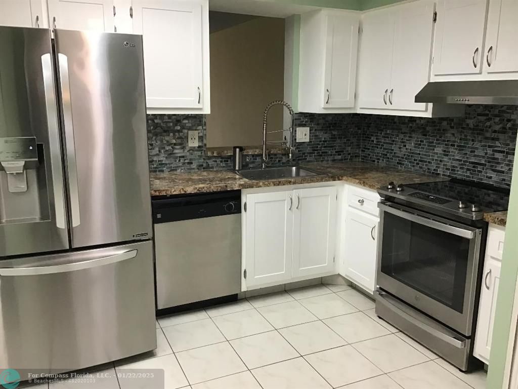 a kitchen with cabinets and stainless steel appliances