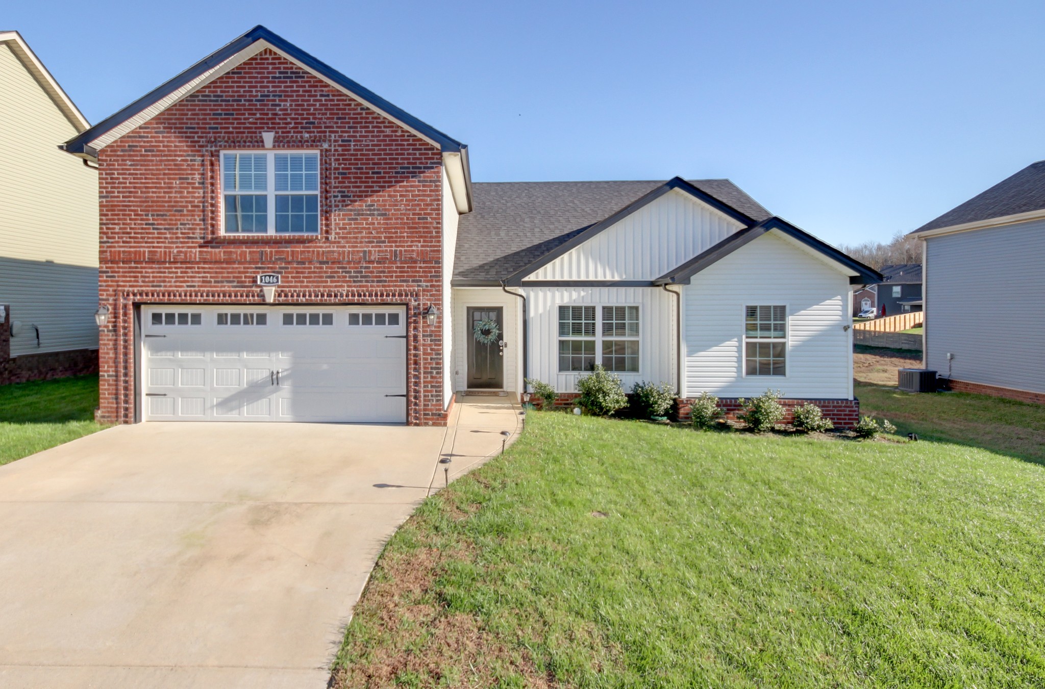 a front view of a house with a yard and garage