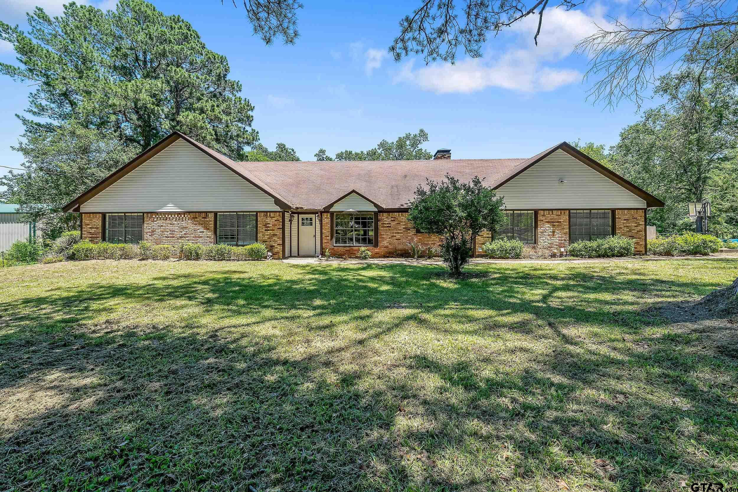 a front view of a house with a yard and trees