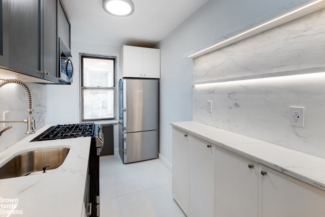 a kitchen with a refrigerator sink and cabinets