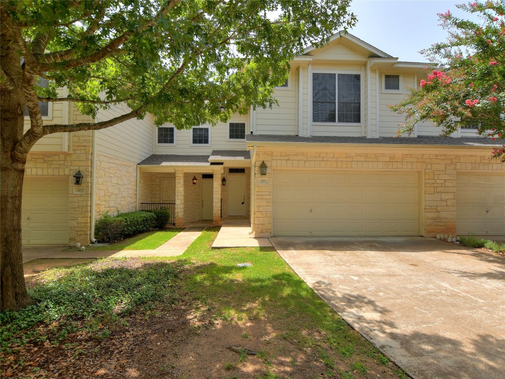 a front view of a house with a yard and garage