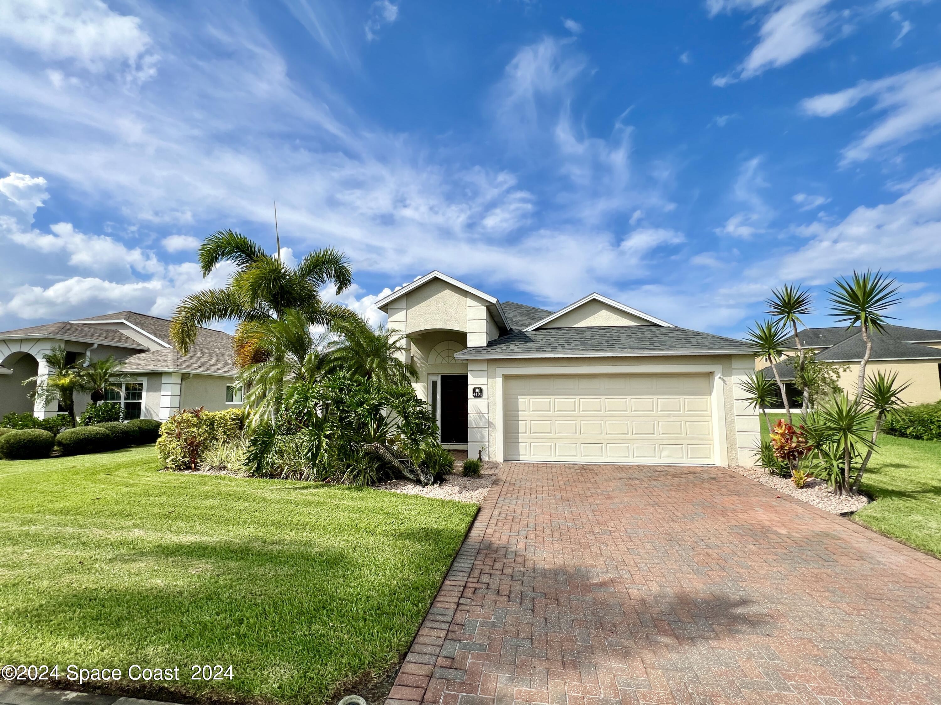 a front view of a house with a garden and yard