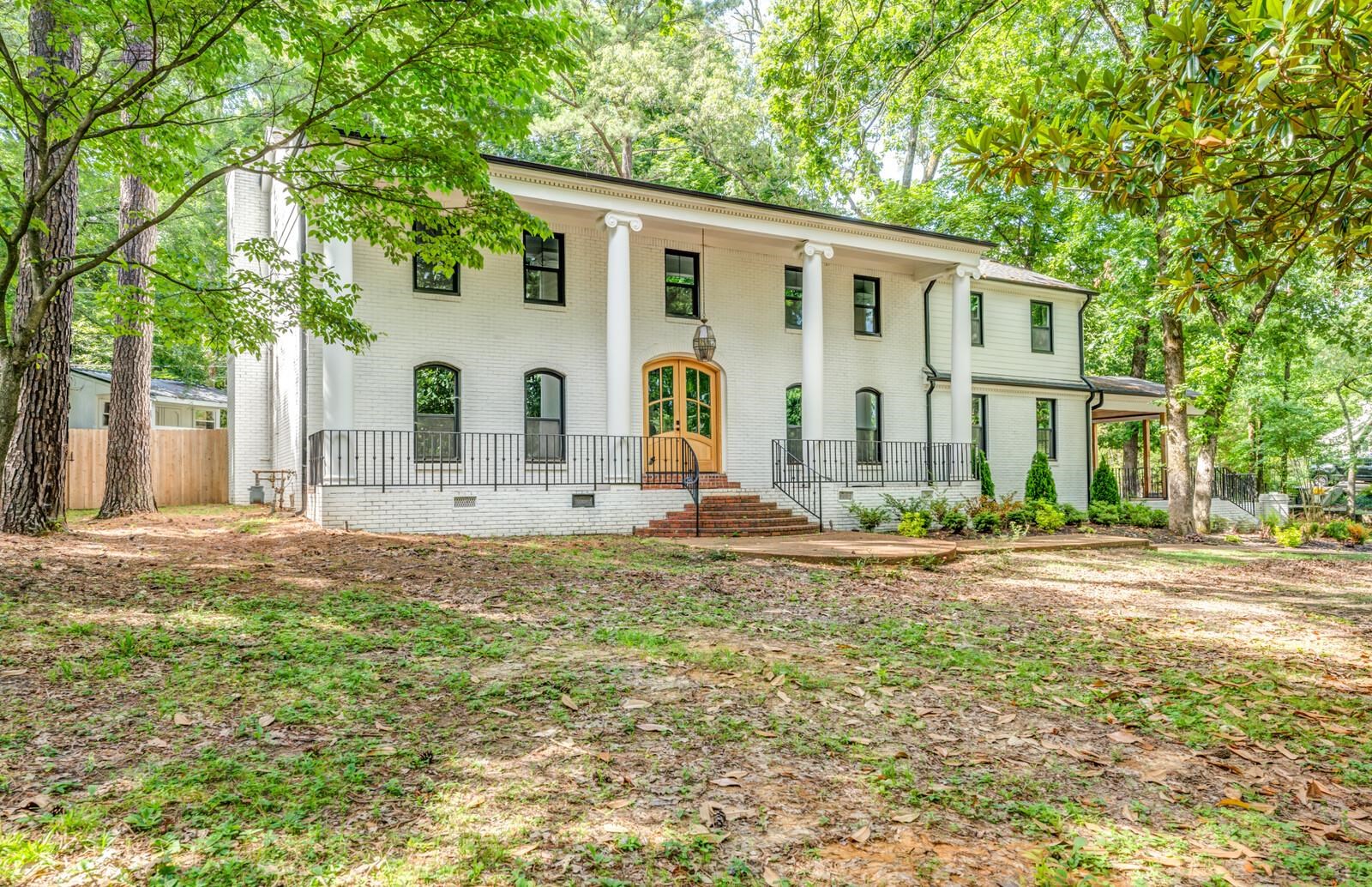 a view of a house with backyard and trees