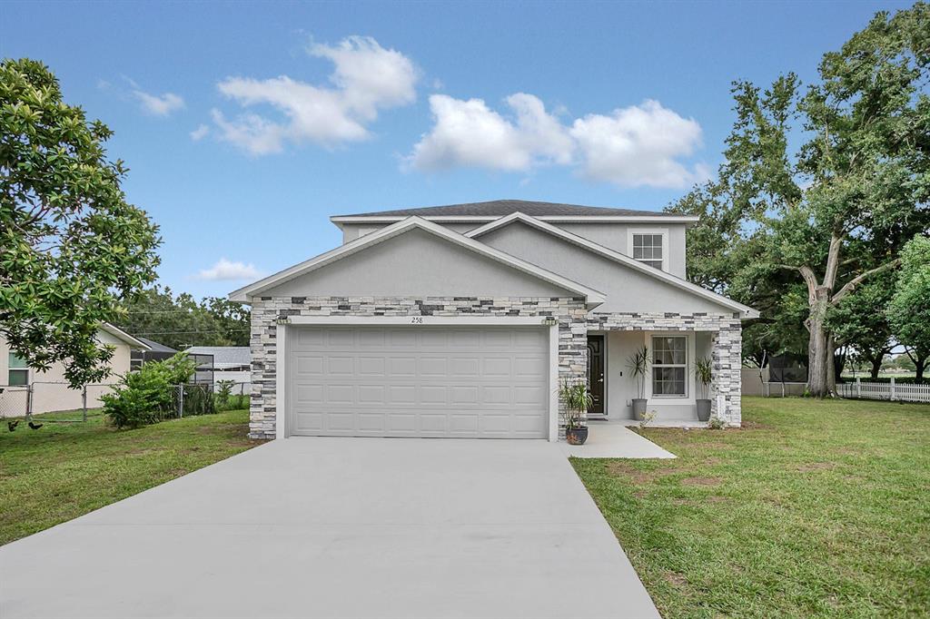 a front view of a house with a yard and garage