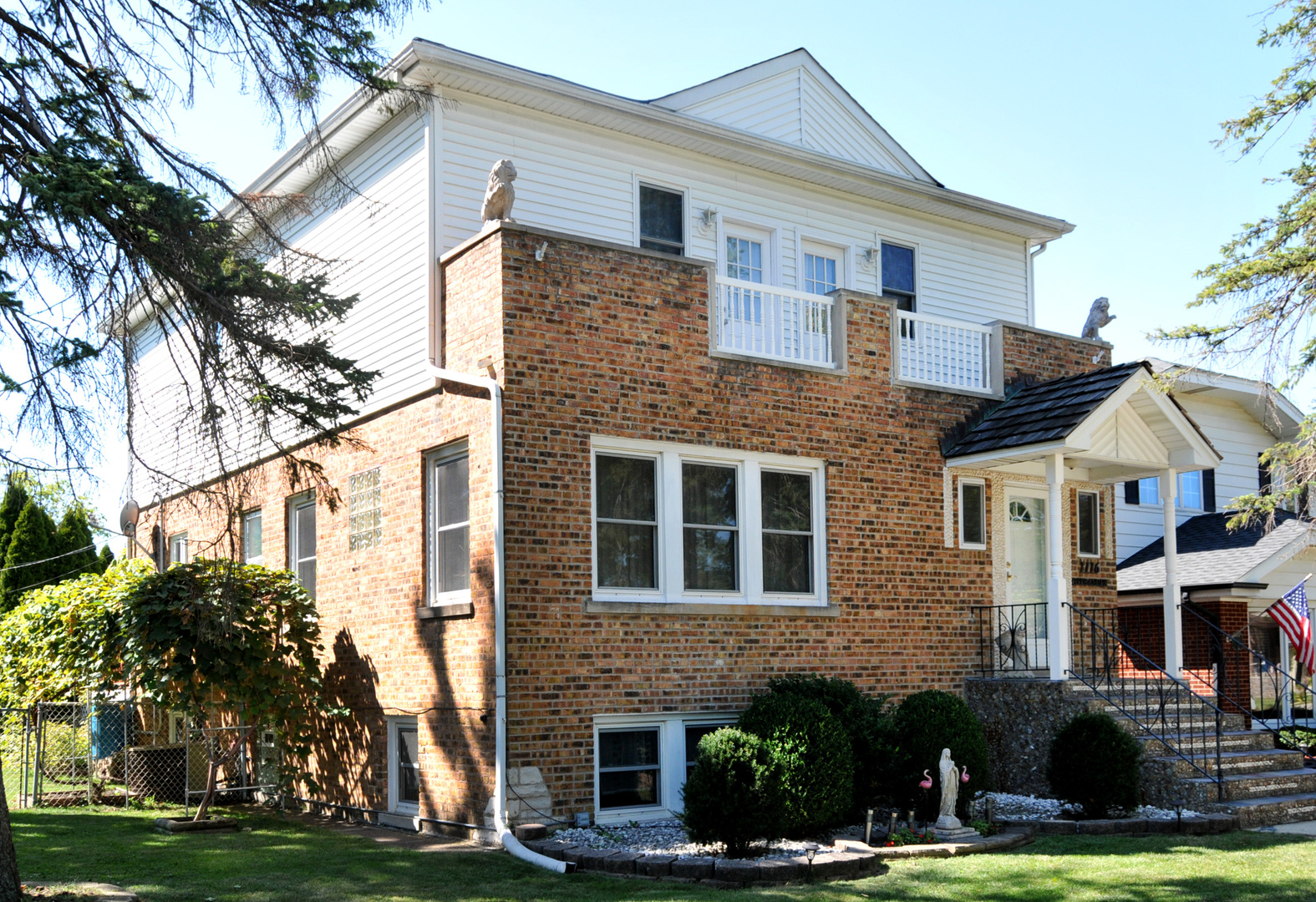 a front view of a house with a garden and trees