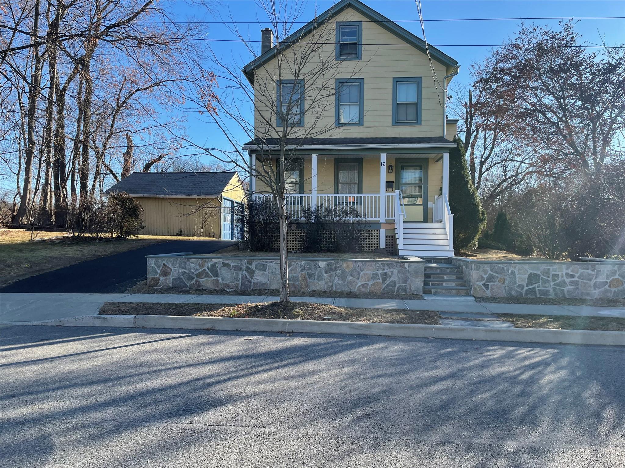 View of front of property with a porch and an outdoor structure