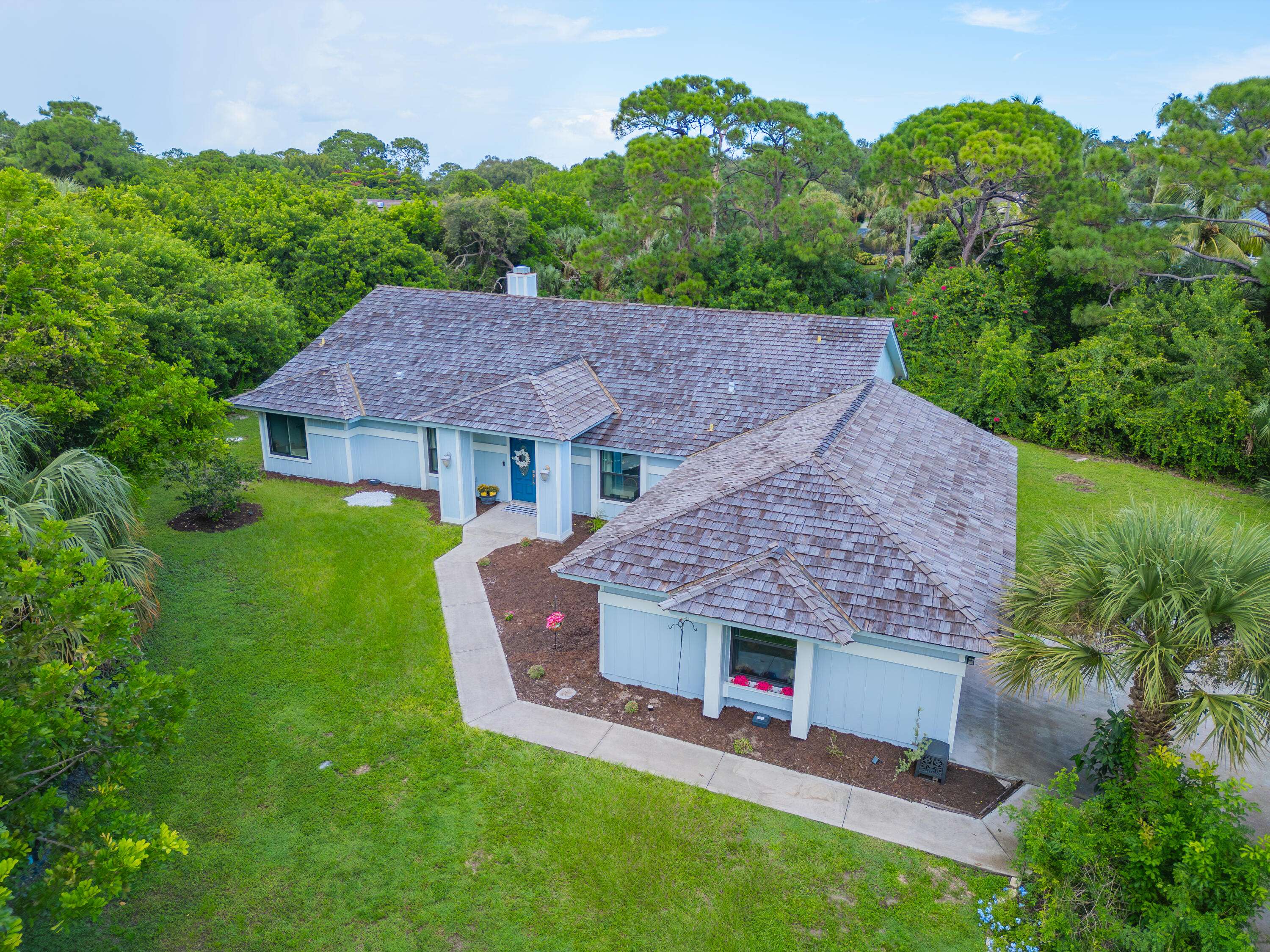 a aerial view of a house with table and chairs under an umbrella