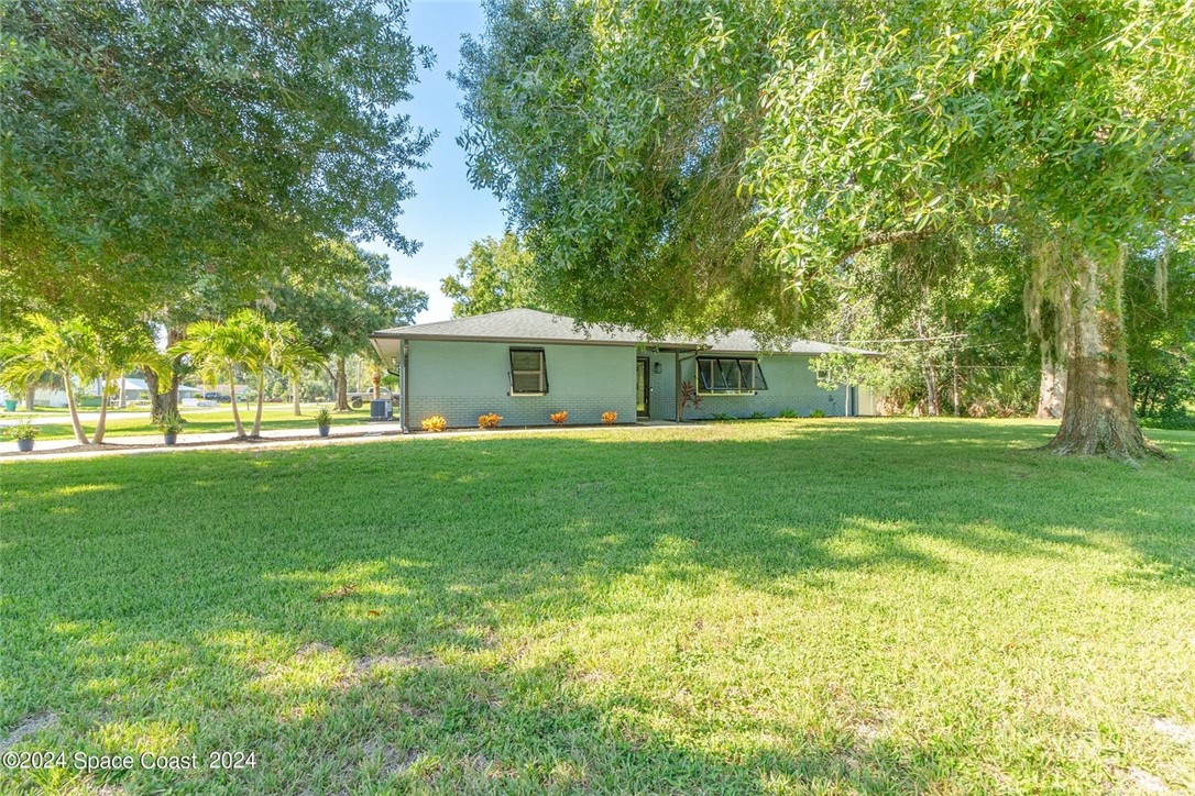 a front view of house with yard and trees