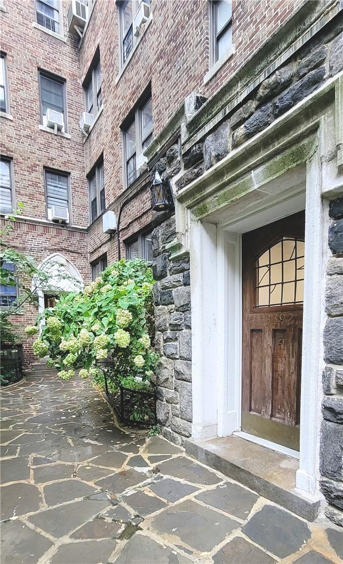 Doorway to property featuring cooling unit and a wall mounted air conditioner