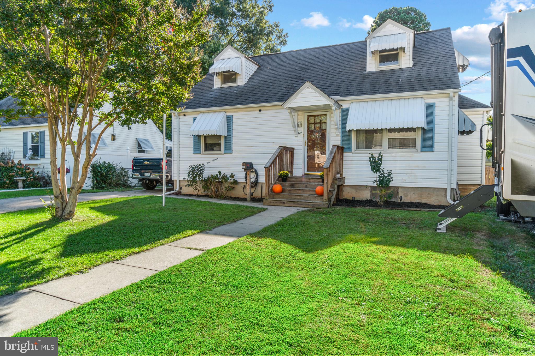 a front view of a house with a yard and trees