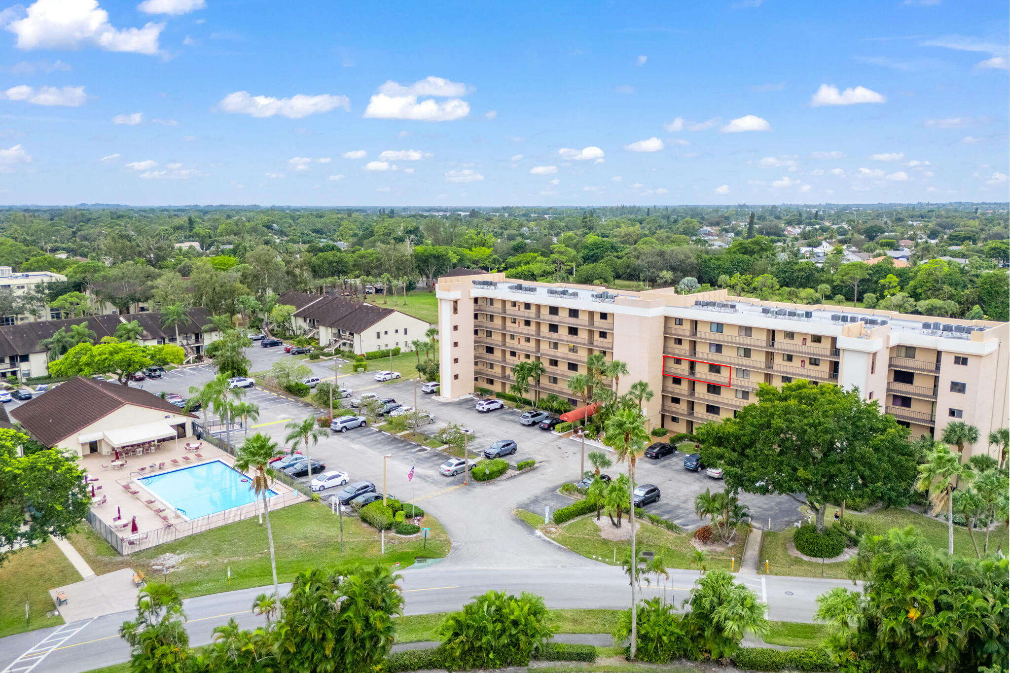 an aerial view of a building with outdoor space and trees all around