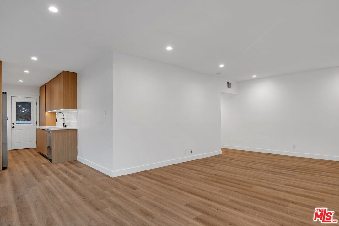 a view of a room with wooden floor and a sink