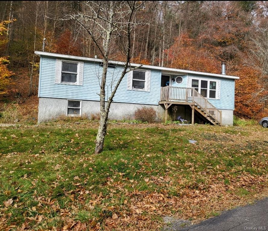 Manufactured / mobile home featuring a deck and a front yard