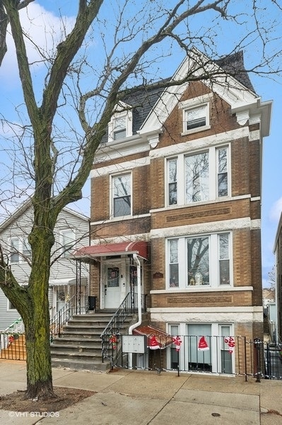 a front view of a building with a tree