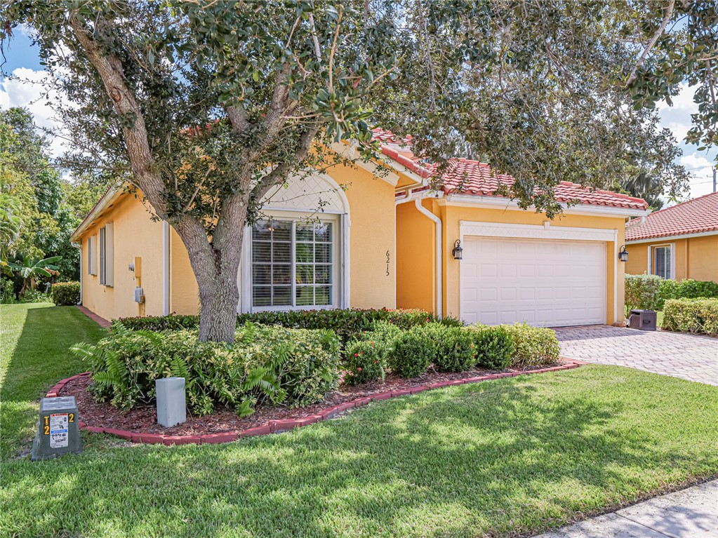 a front view of a house with a yard and trees