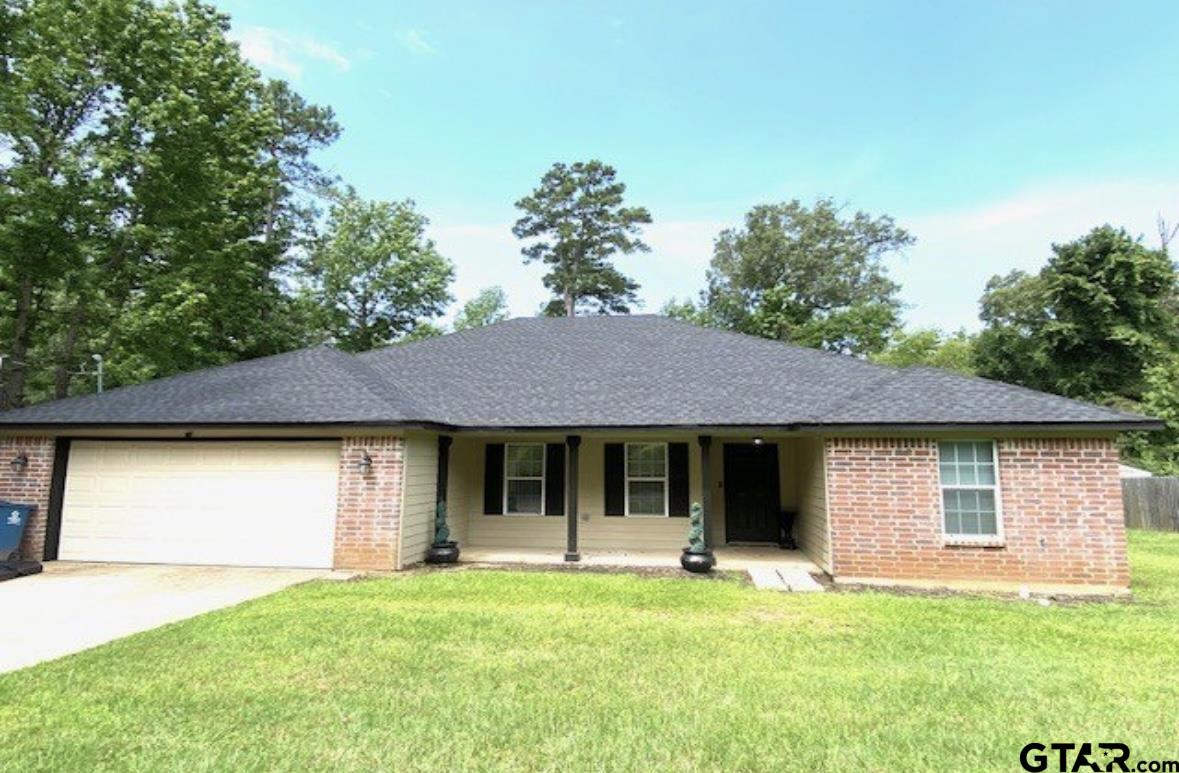 a front view of a house with a garden and trees