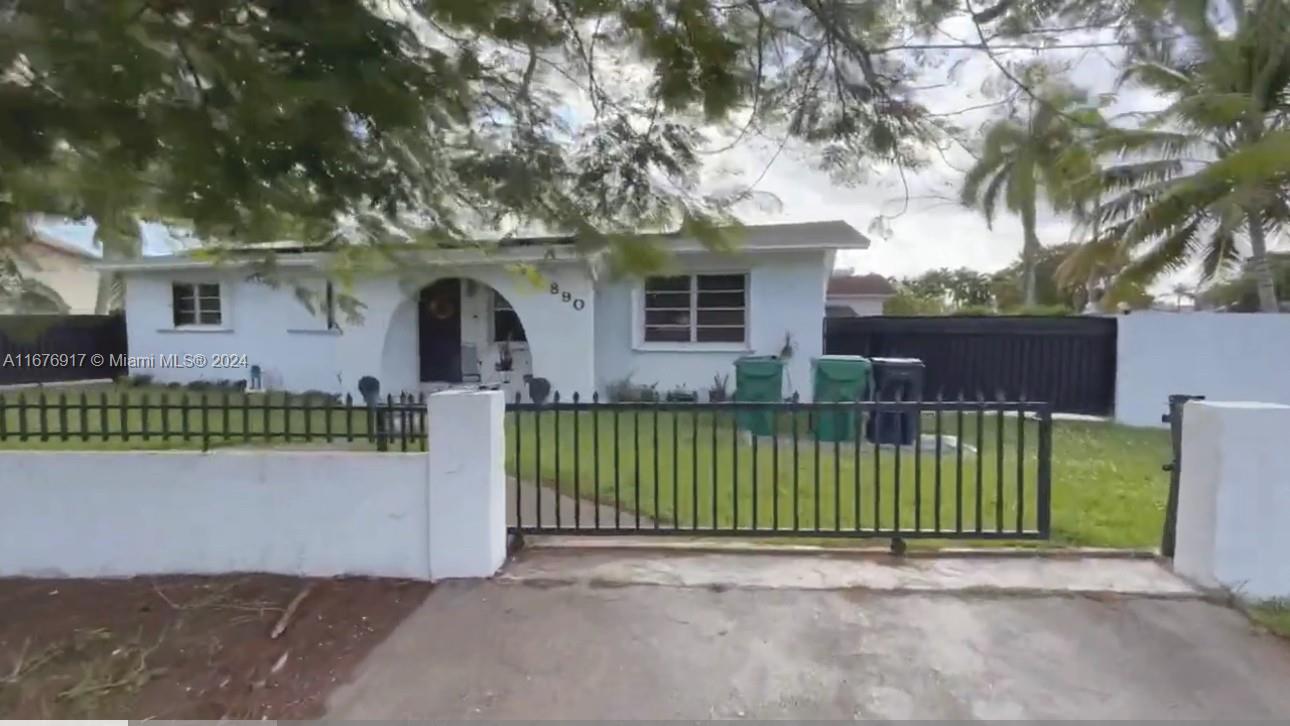 a view of a house with a small yard plants and large tree