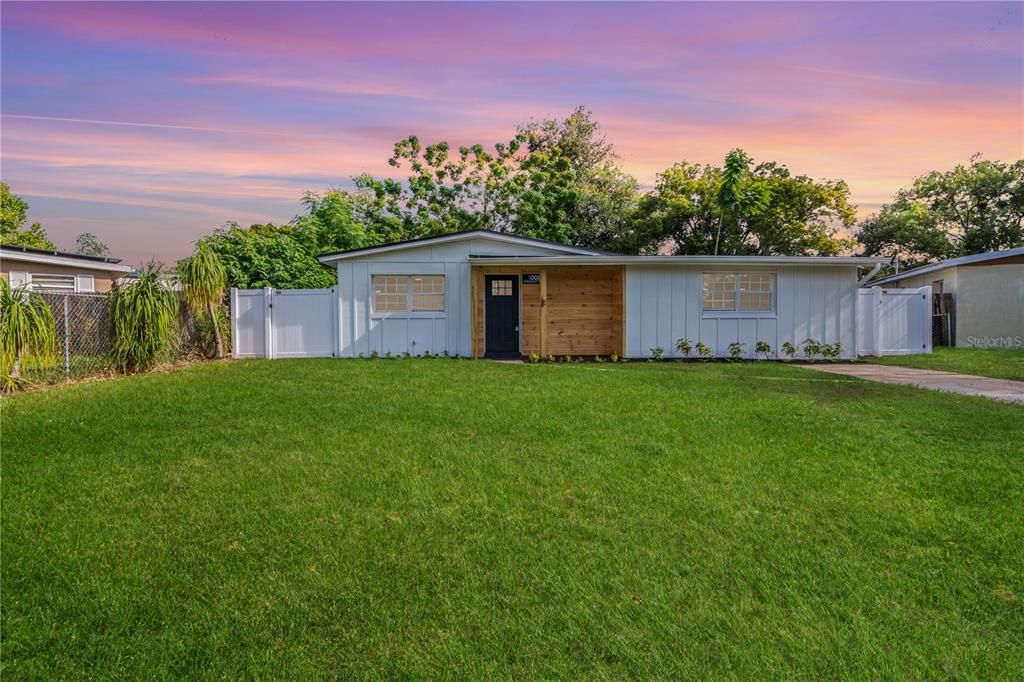 a front view of house with yard and trees in the background