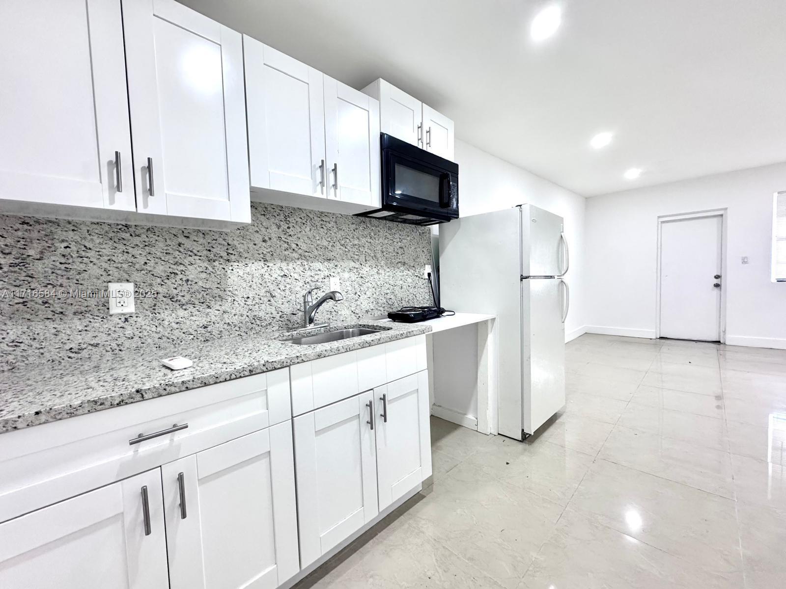 a kitchen with appliances a sink and cabinets