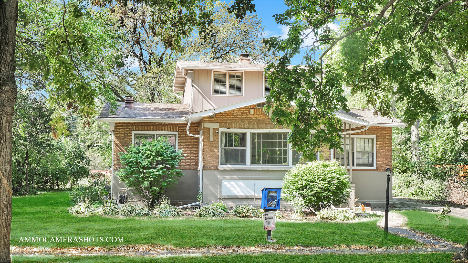 front view of a house with a yard and an trees