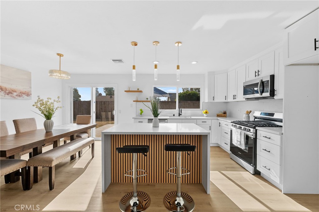 a kitchen with stainless steel appliances granite countertop a stove and cabinets