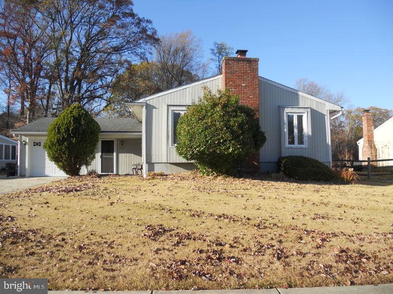 a front view of a house with a yard covered in snow