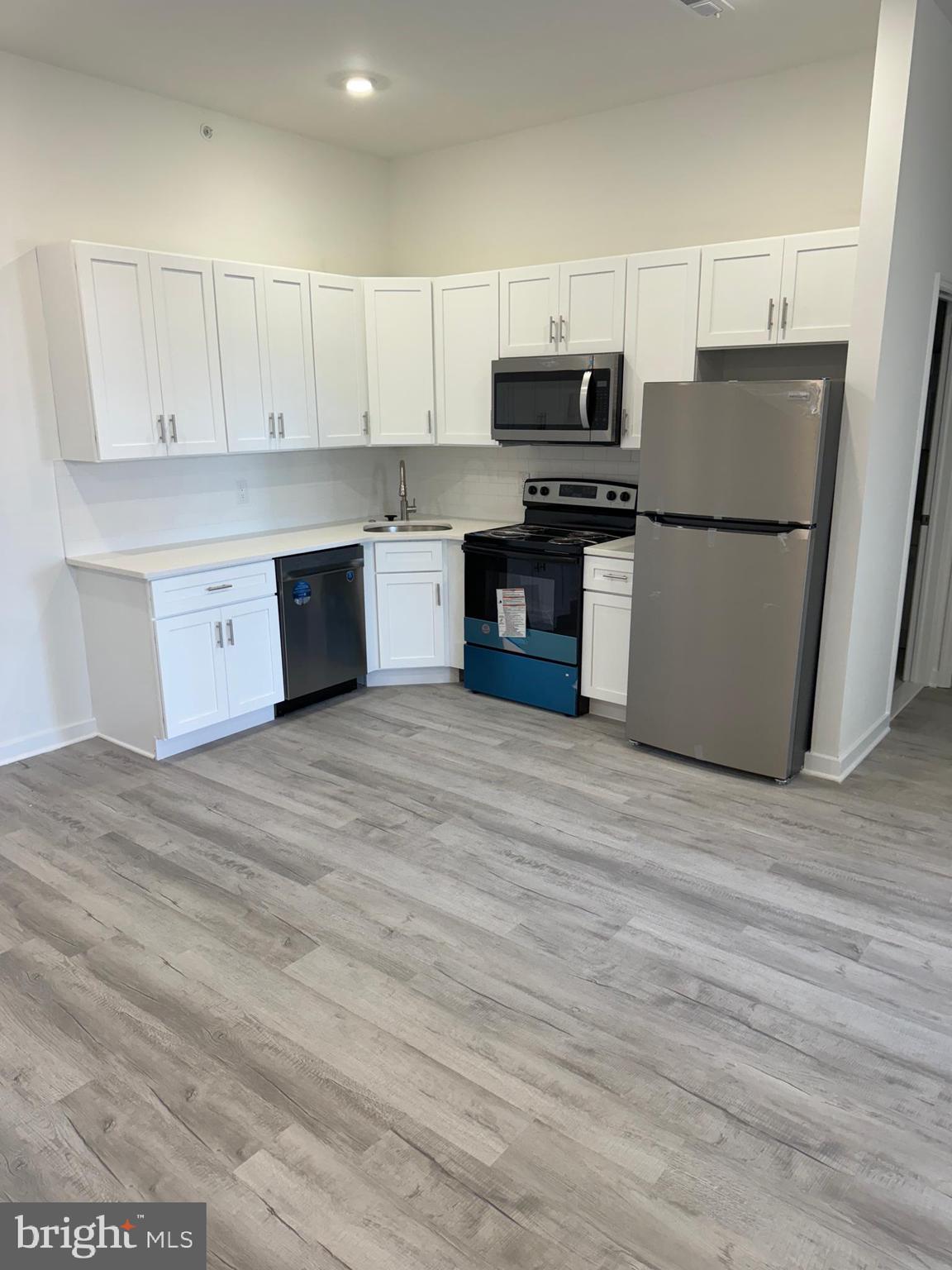 a kitchen with stainless steel appliances a refrigerator and a stove top oven