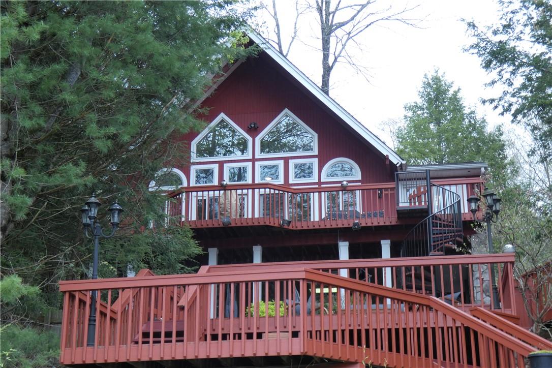 Exterior view of the home from the lake in the snow.