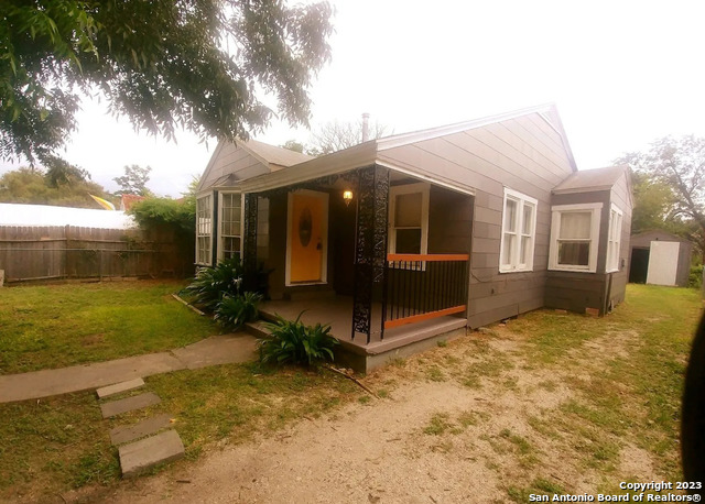 a view of a house with backyard and a tree