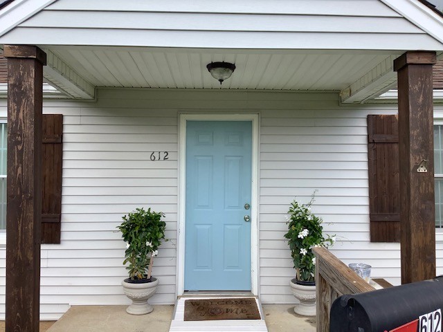 a view of small house with potted plants