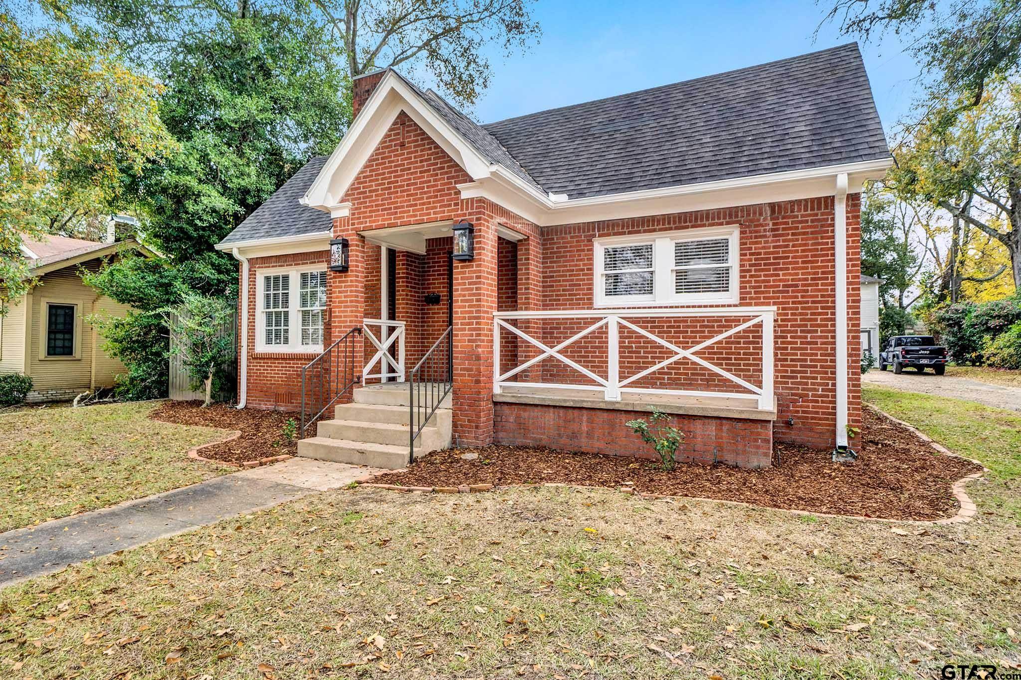 a view of a house with wooden fence next to a yard